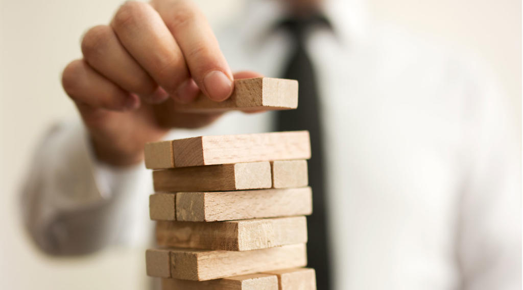 photo of a businessman stacking blocks high on top of one another