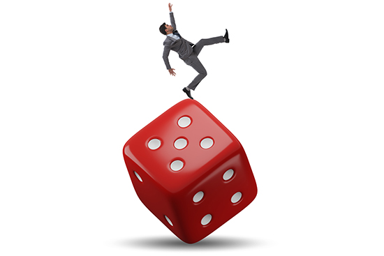 physically unstable businessman trying to balance on top of dice